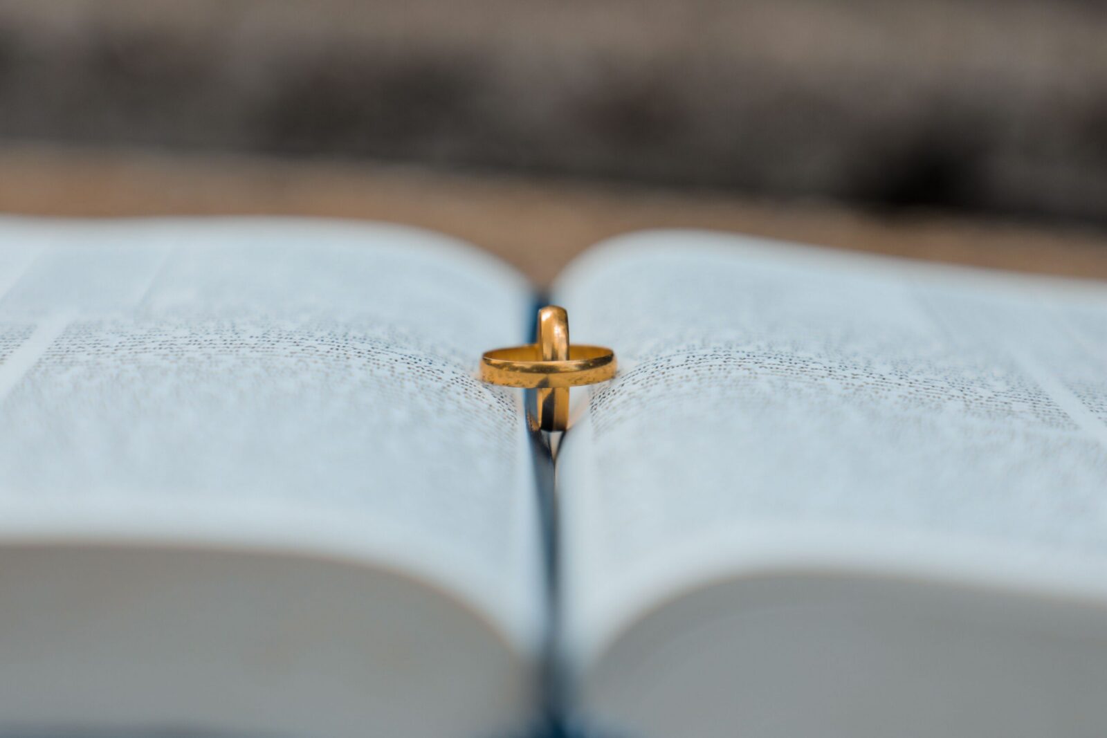 High angle of golden wedding rings placed on opened book during marriage registration